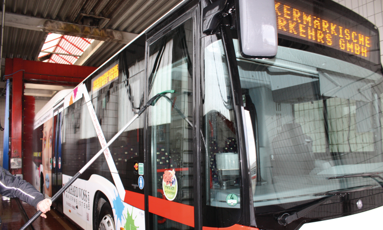 Ein Bus wird in einer Waschanlage gesäubert.