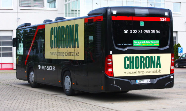 Abgebildet ist ein Bus, der mit Werbestickern der Marke "CHORONA" versehen ist.