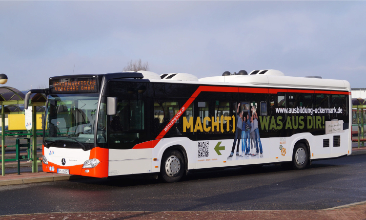 Abgebildet ist ein Bus, der mit der Aufschrift Mach(t) was aus dir! versehen ist.