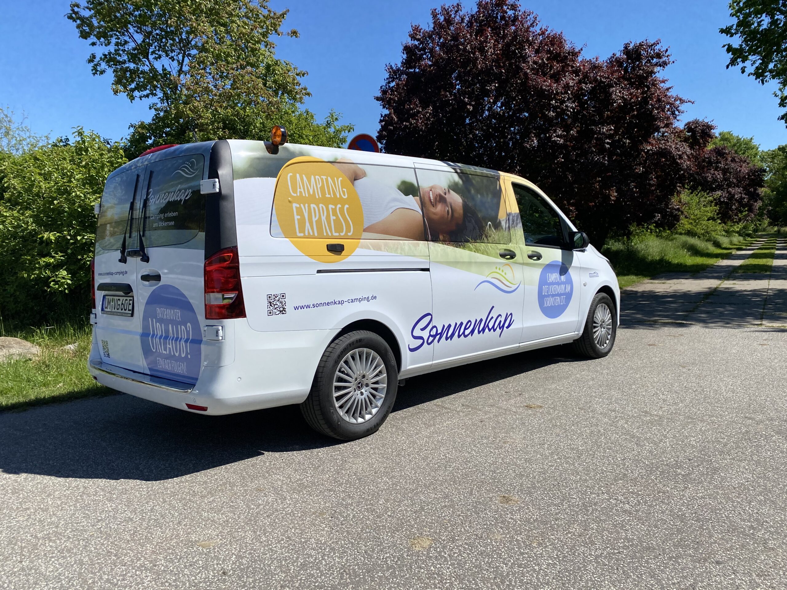 Bus mit auffälligen Beschriftungen wie „Sonnenkap“ und „Camping Express“