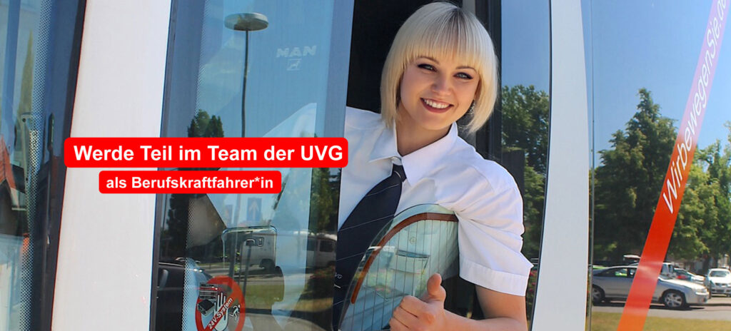 Eine Busfahrerin sitzt im Bus am Steuer.