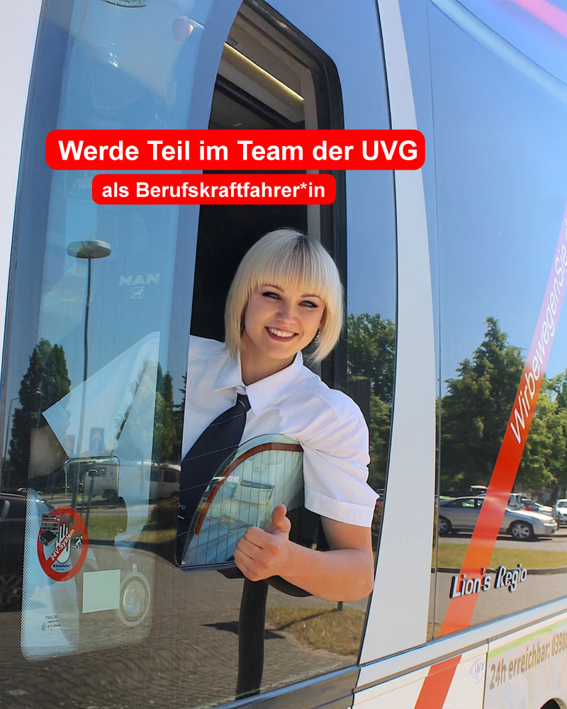 Eine Busfahrerin sitzt im Bus am Steuer.
